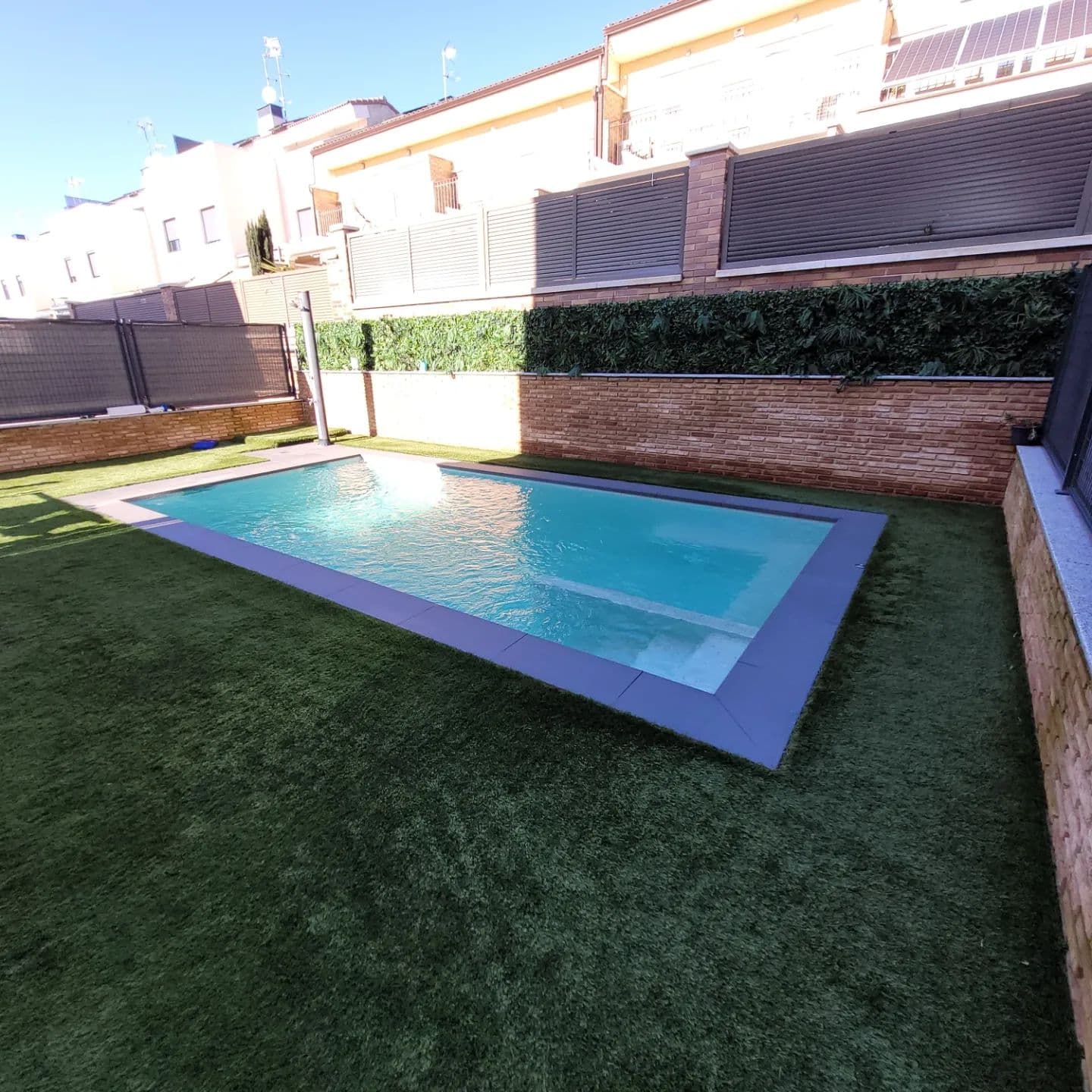 Piscina junto a vivienda de ladrillo